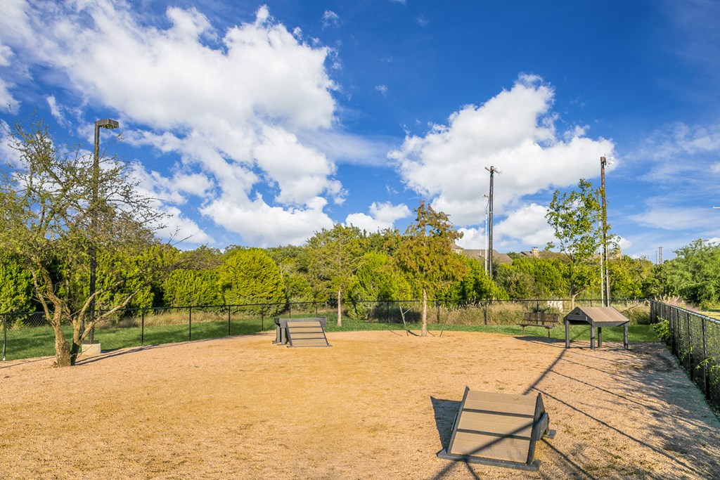a park with a picnic table and a chain link fence