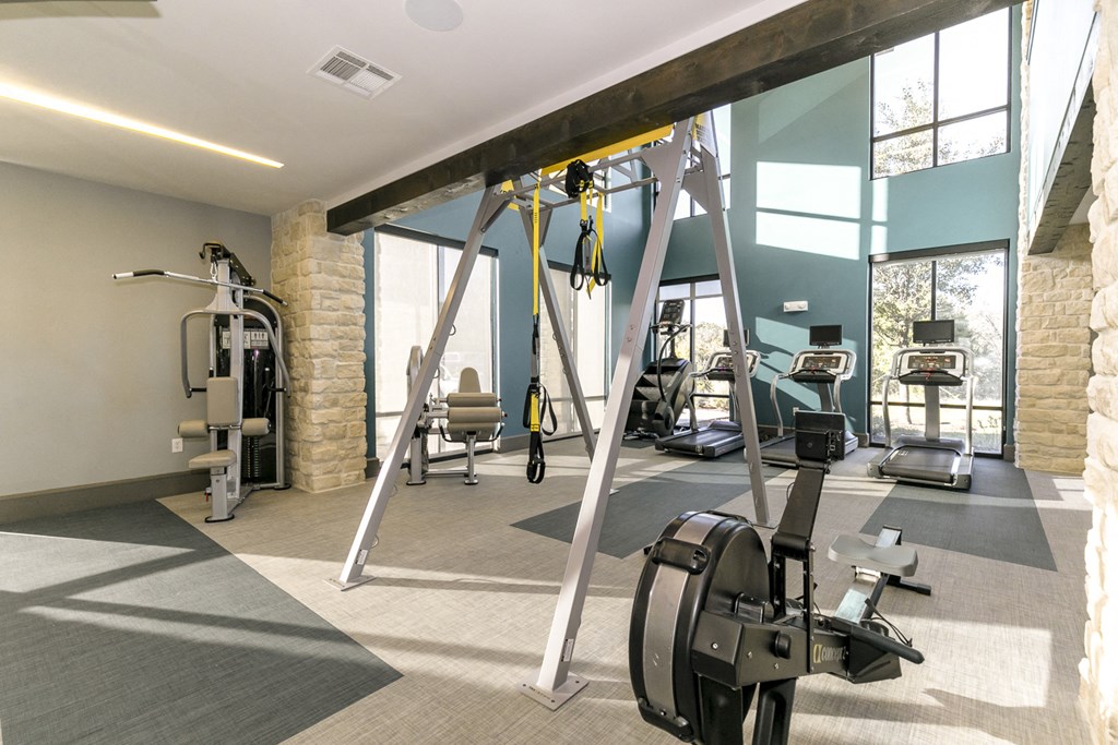 a gym with weights and other exercise equipment and windows