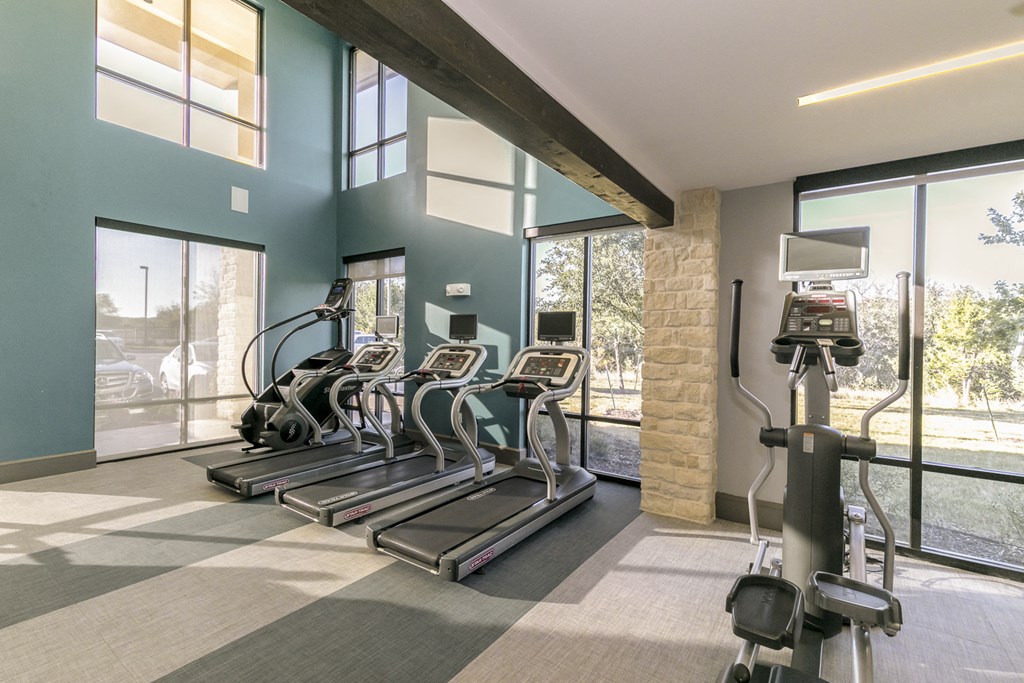 a gym with cardio equipment and windows at the village