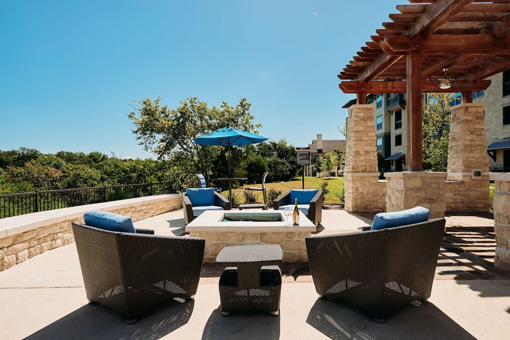 a patio with chairs and a fire pit