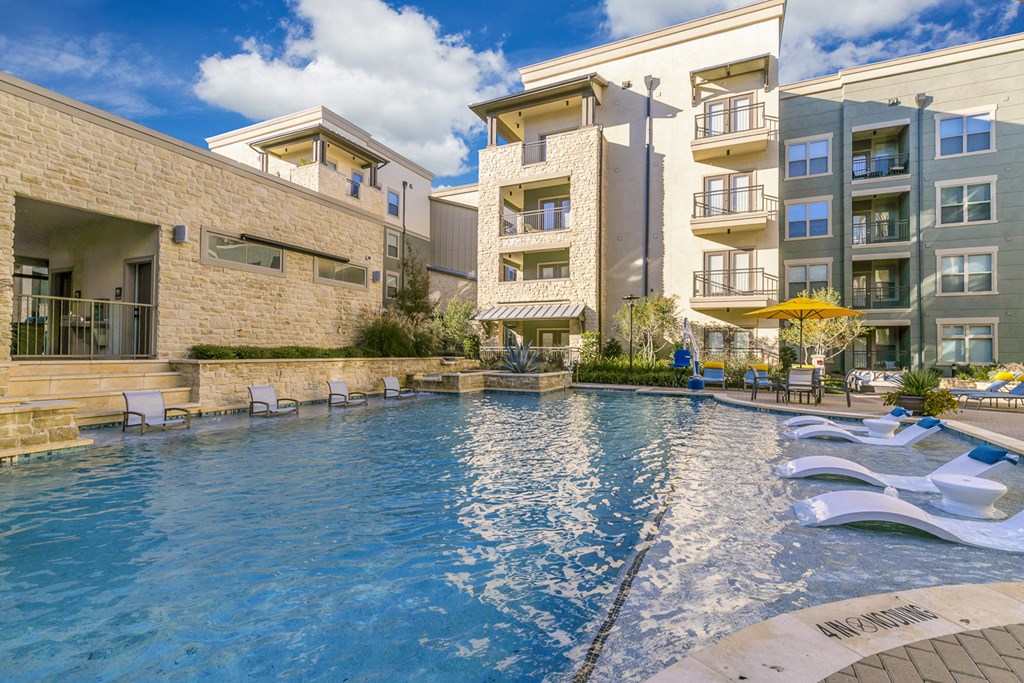 a large swimming pool in front of an apartment building