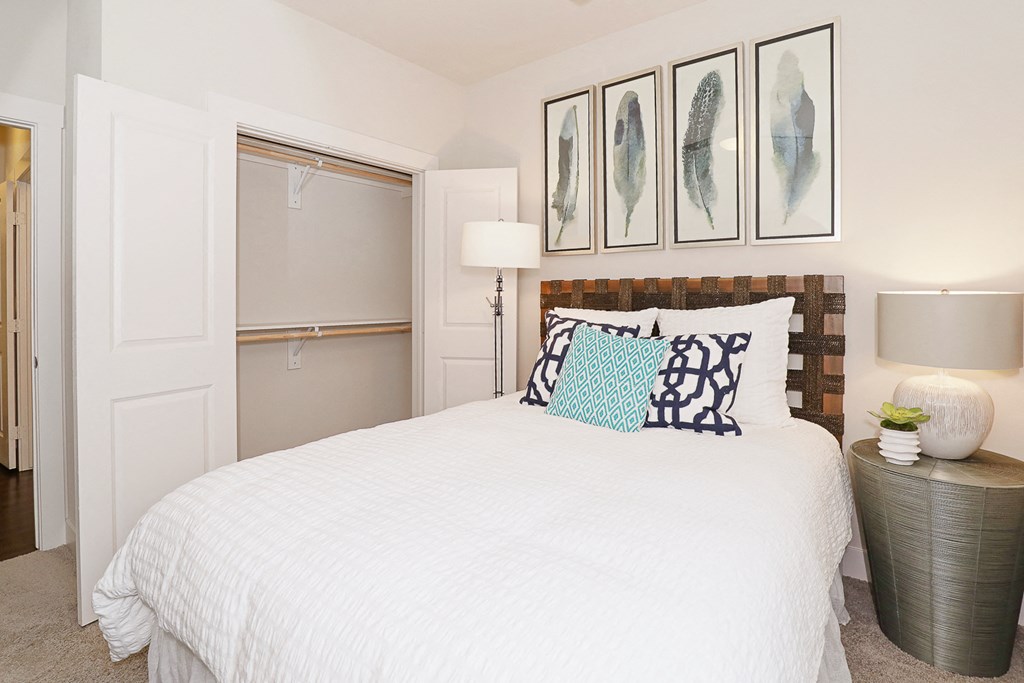 a bedroom with a white bed and some pictures on the wall