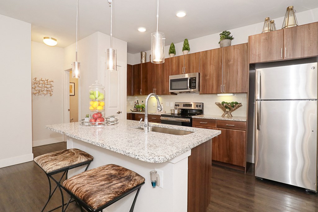 a kitchen with stainless steel appliances and a marble counter top
