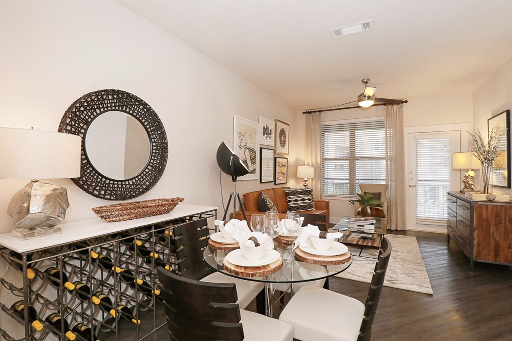 a living room with a dining room table and chairs and a kitchen with a bar