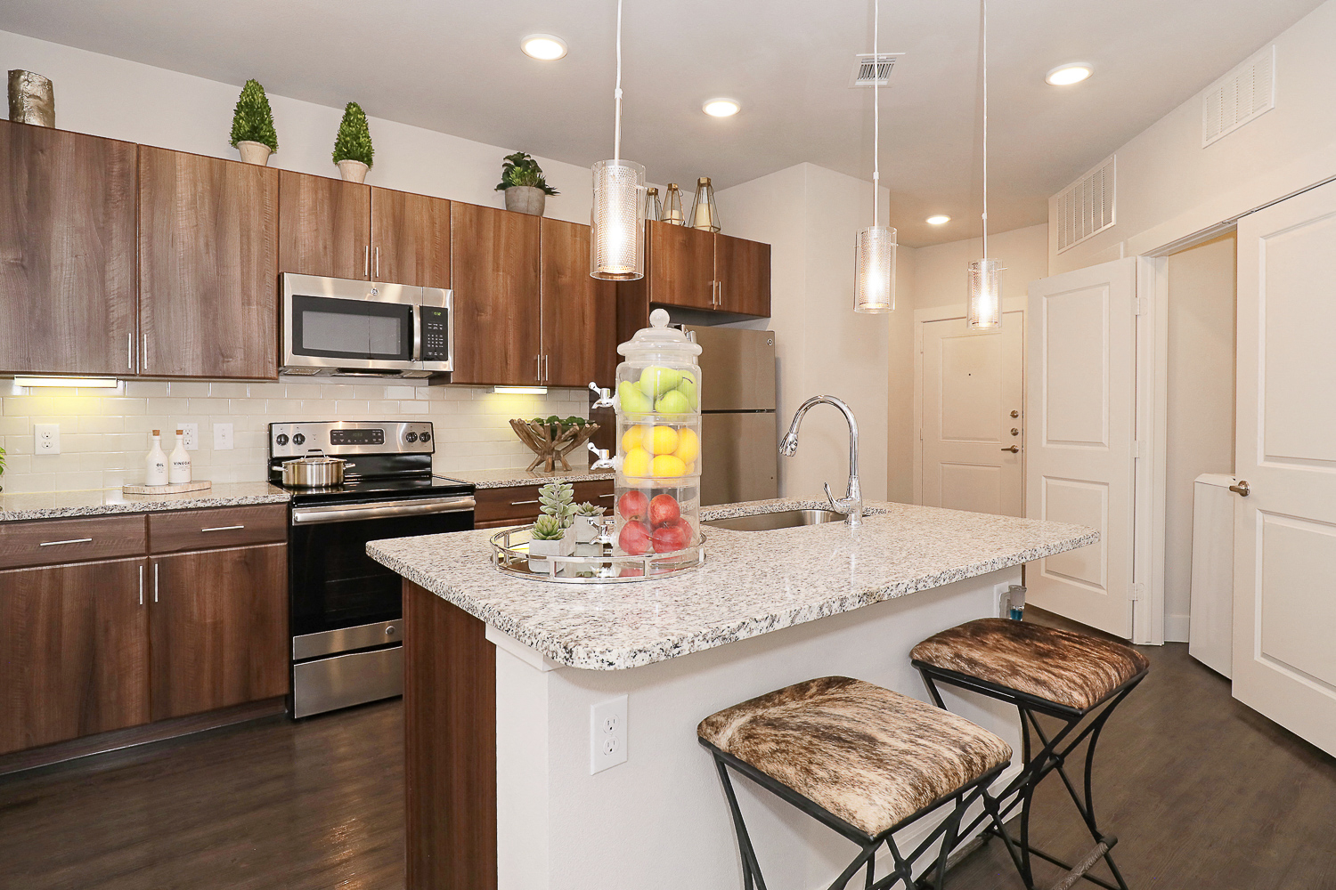 a kitchen with a marble counter top with two stools