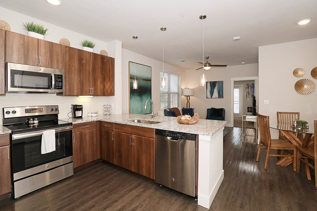a kitchen and dining room with wooden cabinets and stainless steel appliances