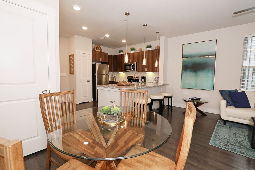 a kitchen and dining room with a glass table and chairs