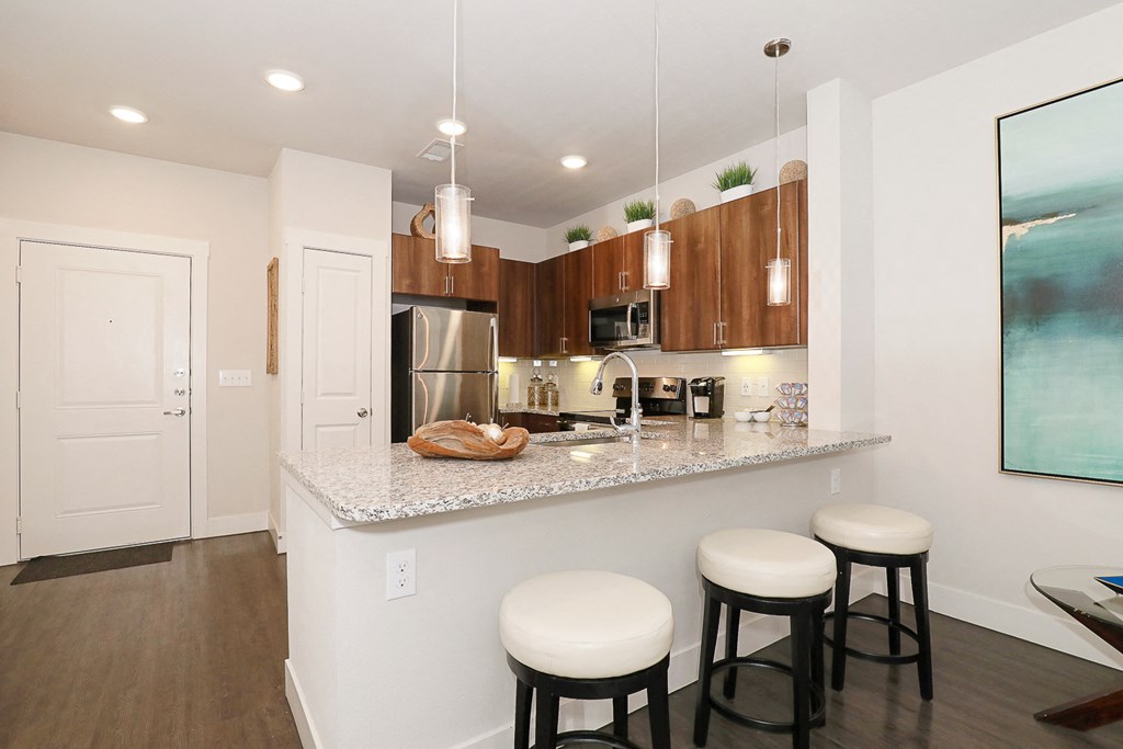 a kitchen with a counter and three stools