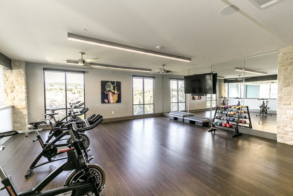 a workout room with bikes and a tv in a house