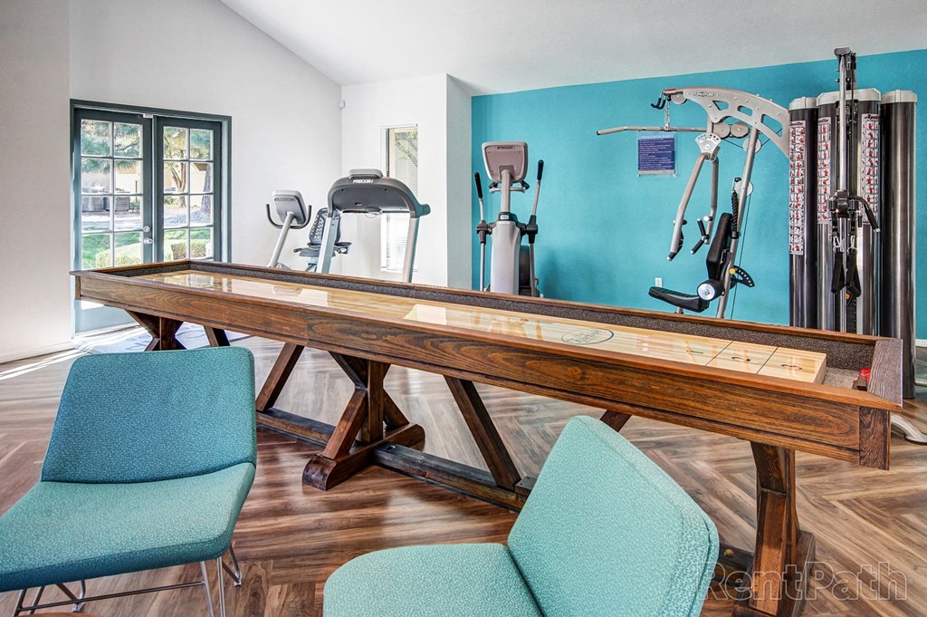 a game room with a pool table and chairs