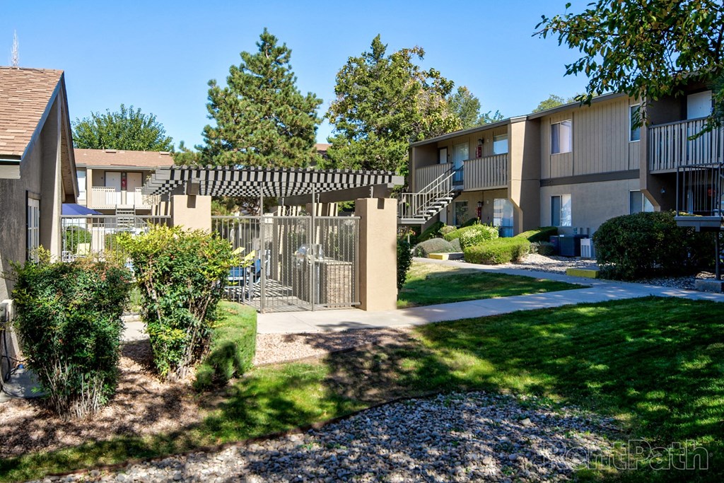 an exterior view of an apartment building with a yard and sidewalk
