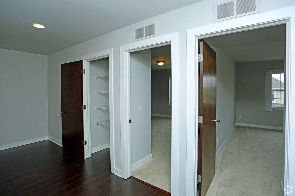 a bedroom with three closets and a door to a closet