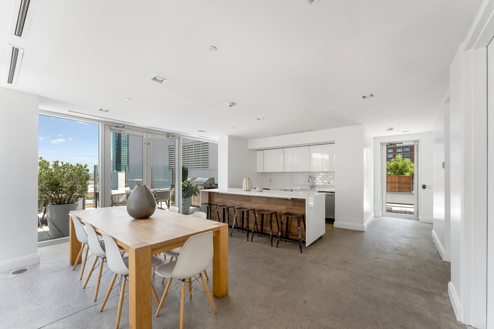 A modern kitchen with a dining table and chairs is shown.