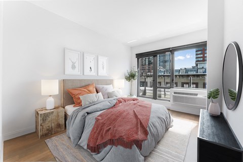 A bedroom with a large bed and a view of the city.