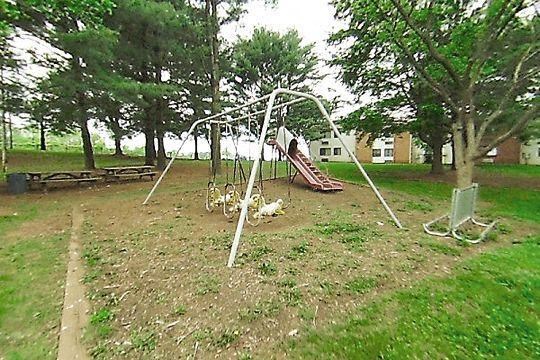 a swing set in a park with trees