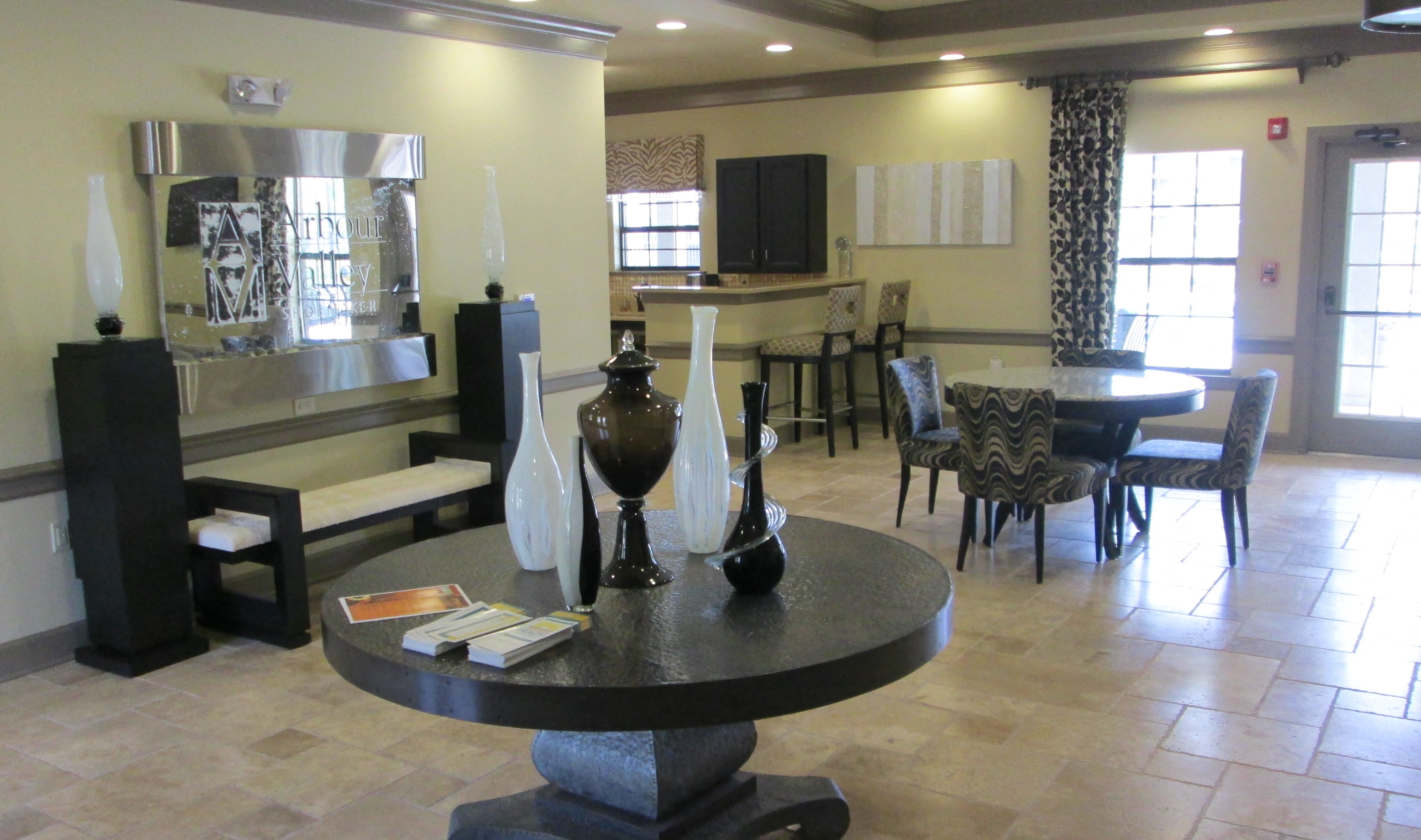 a living room with a table and chairs and a kitchen