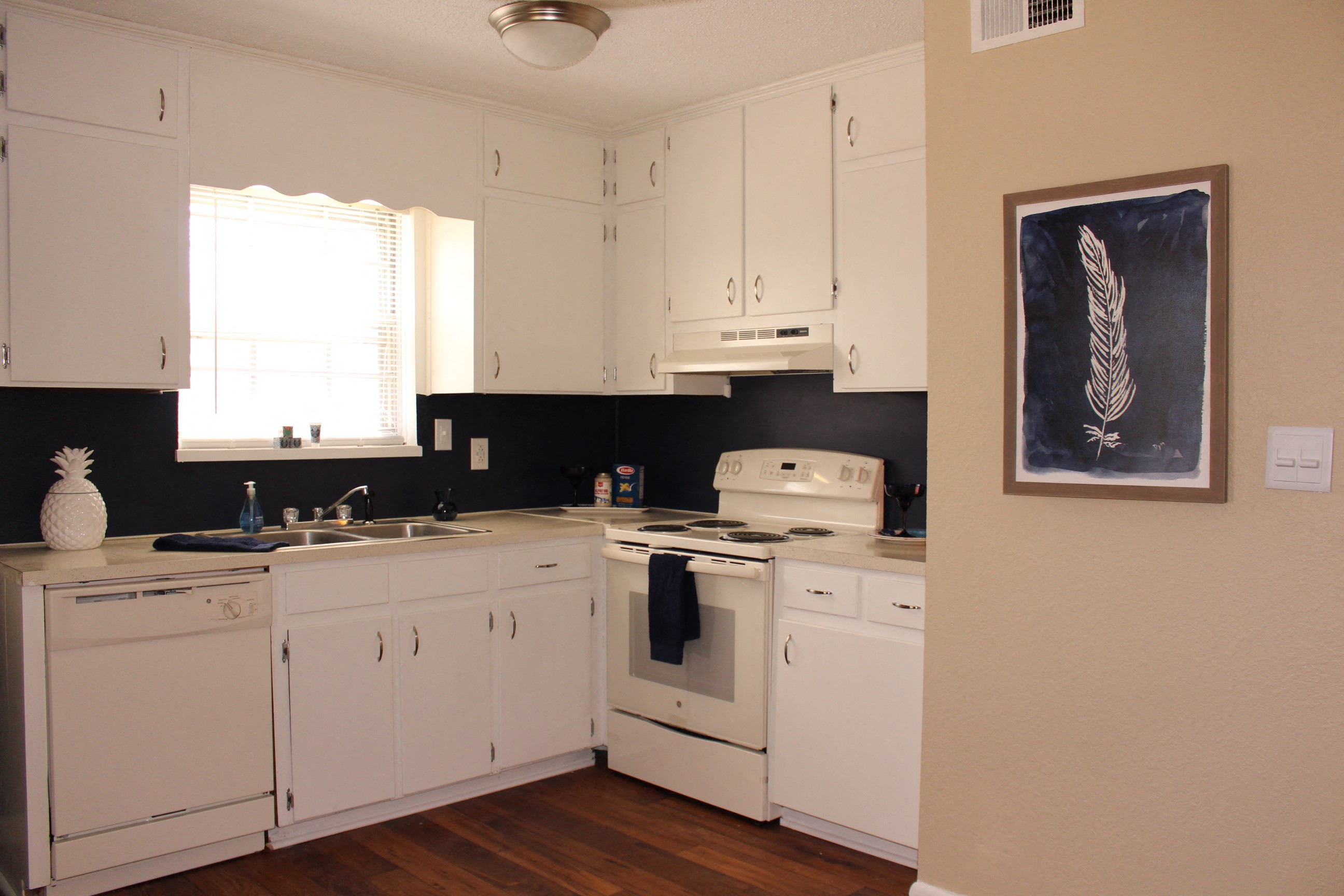 a view of a kitchen with white cabinets and a white stove