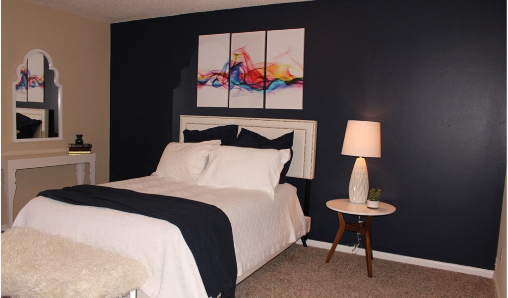 a bedroom with a bed and a table with a lamp