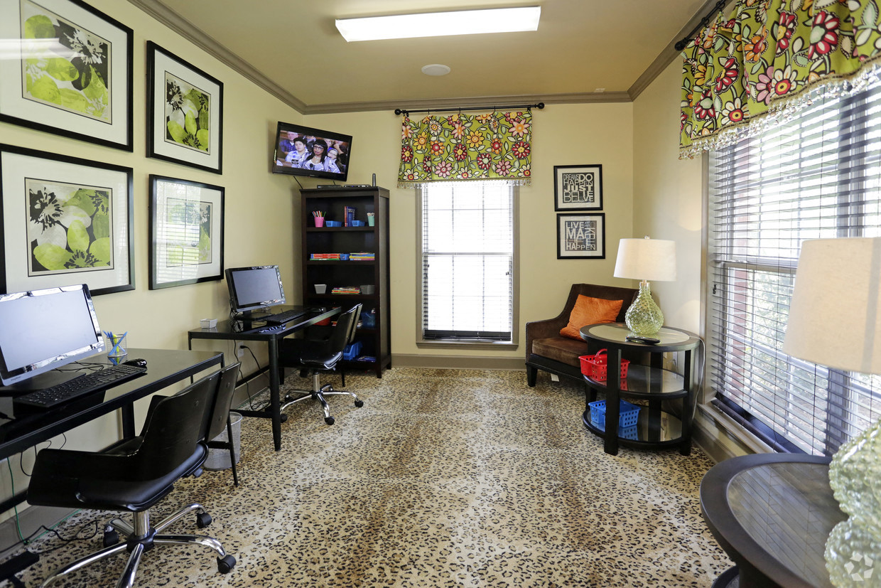 a living room with a desk and a computer