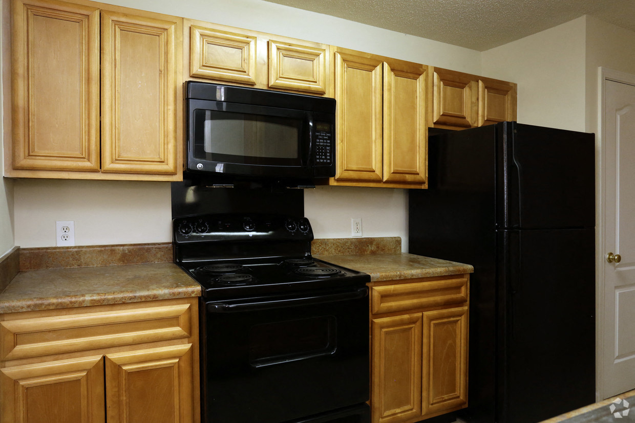 a kitchen with black appliances and wooden cabinets