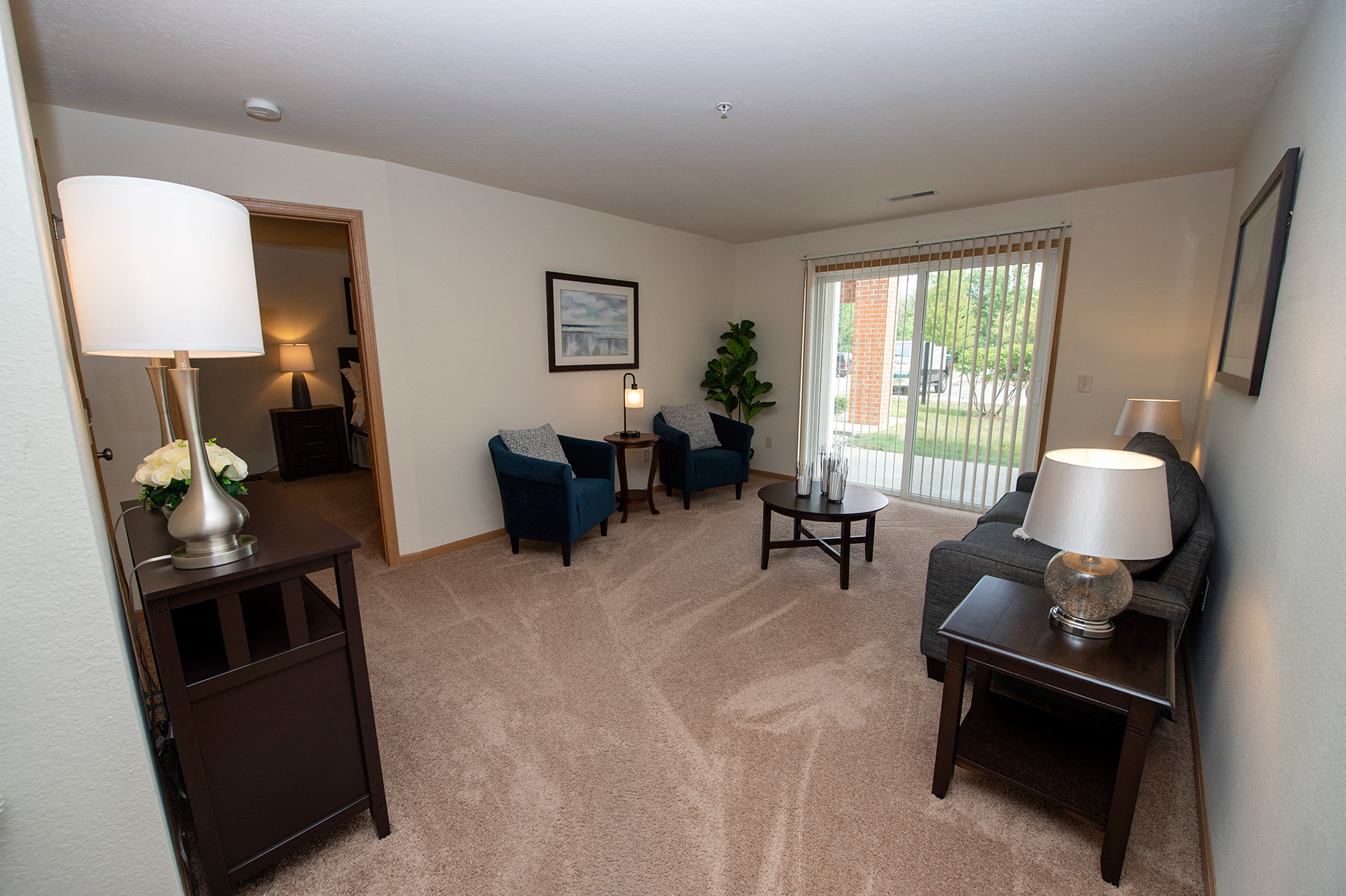 a living room with a couch and chairs and a window