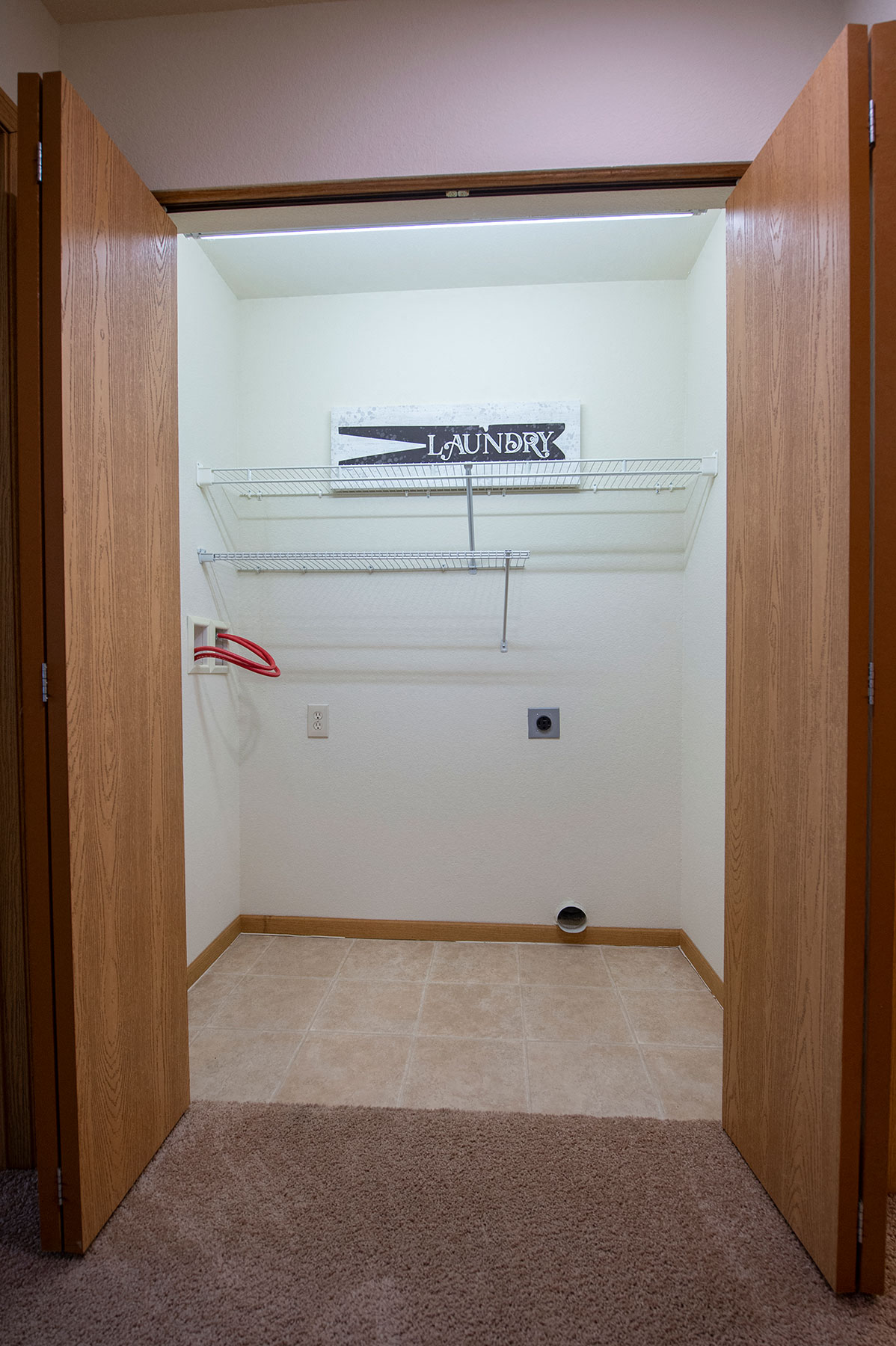 an empty closet with a white wall and a shelf in it