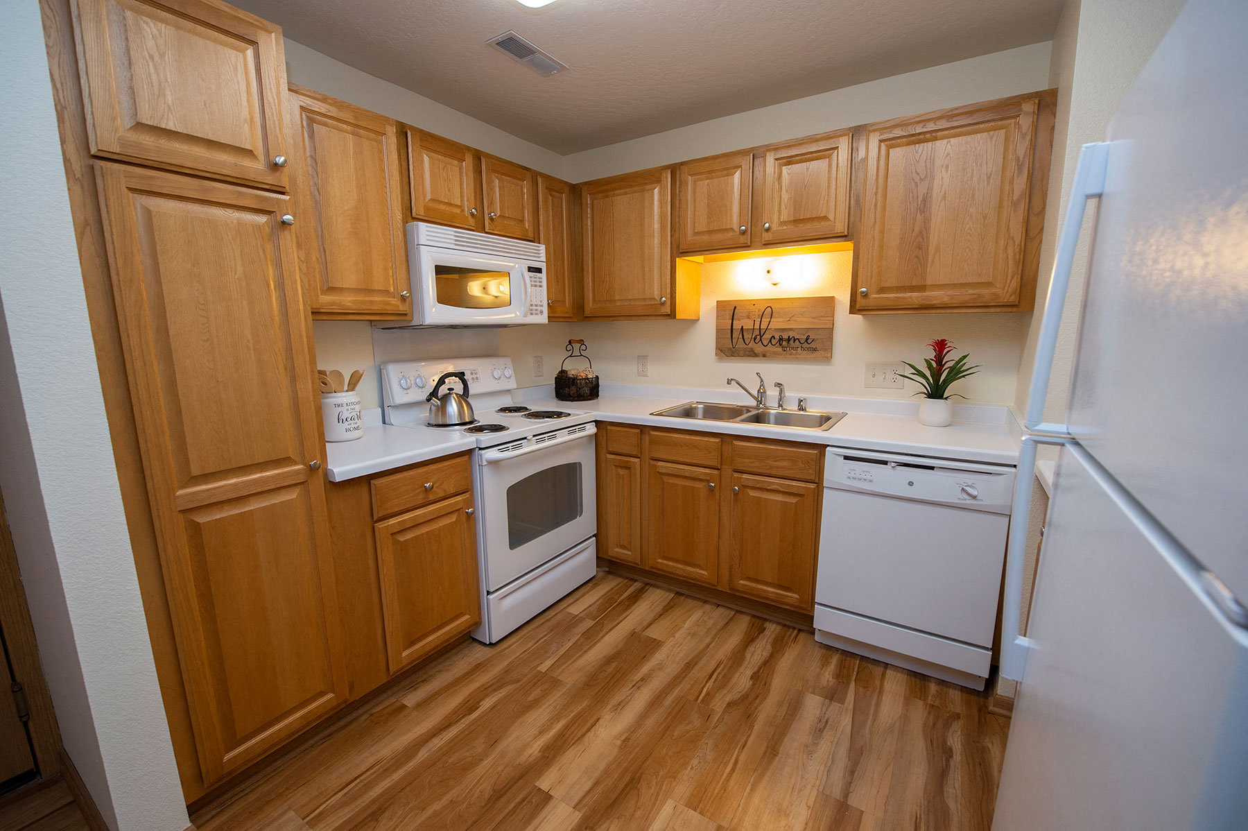 a kitchen with white appliances and wooden cabinets