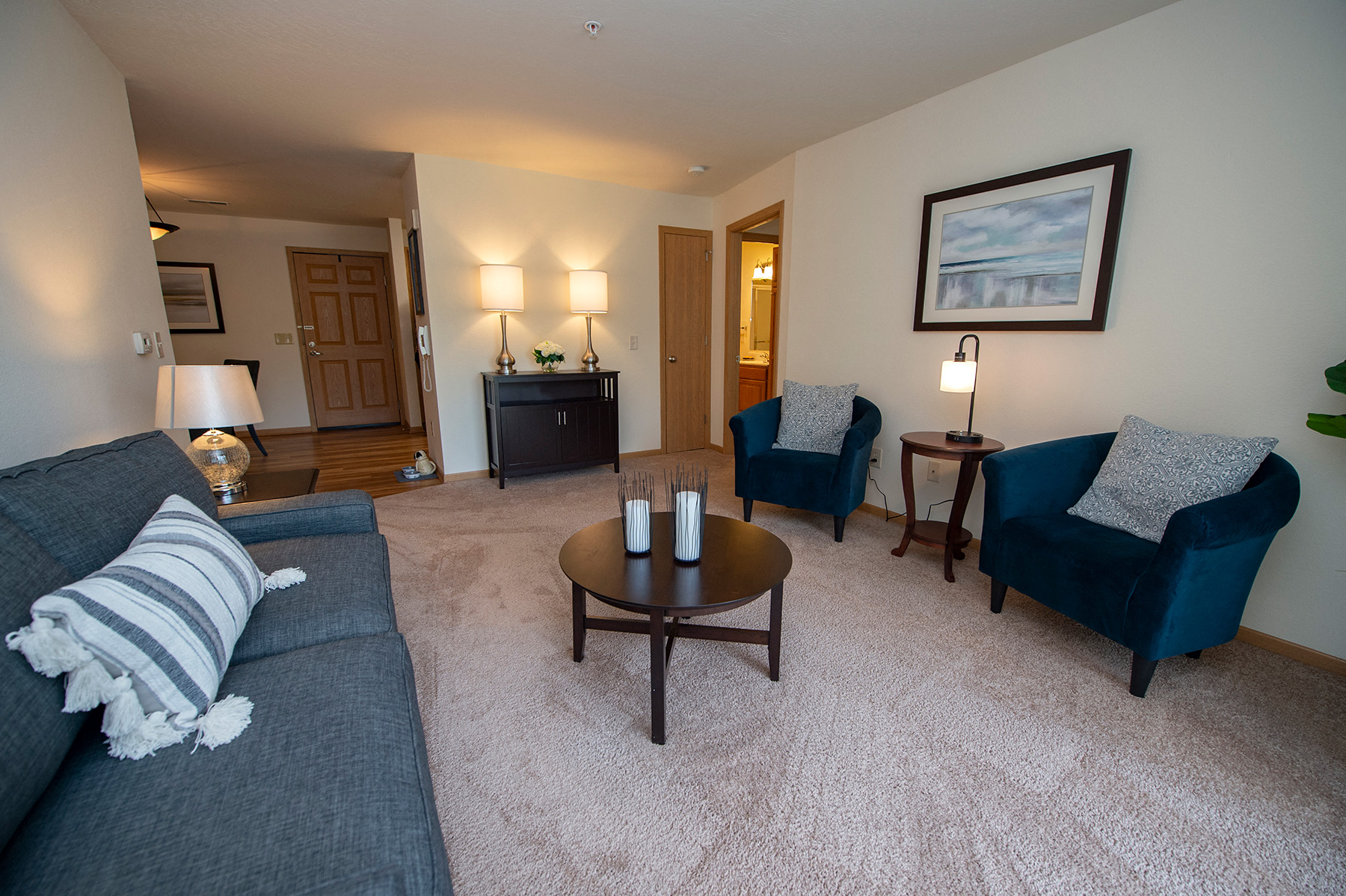 a living room with a couch and two chairs and a table