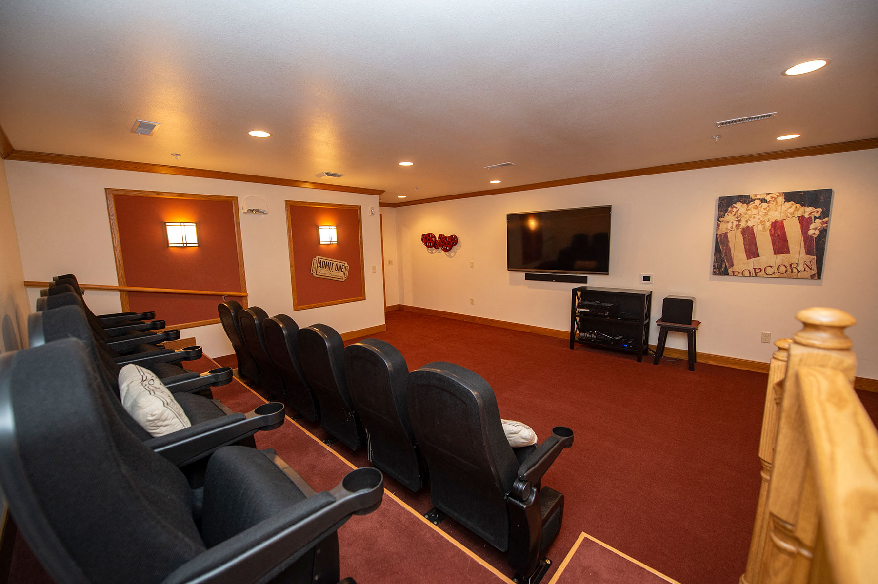 a small screening room with leather chairs and a television