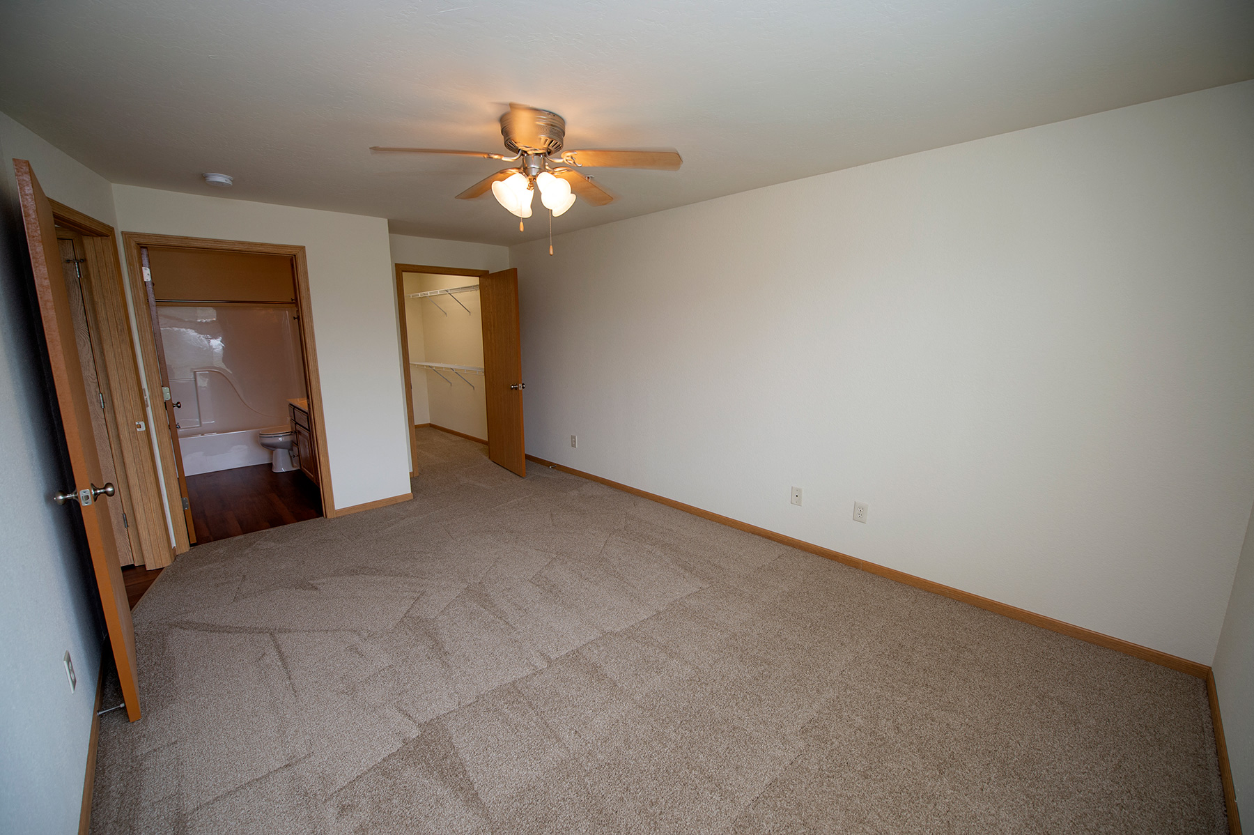 a living room with carpet and a ceiling fan
