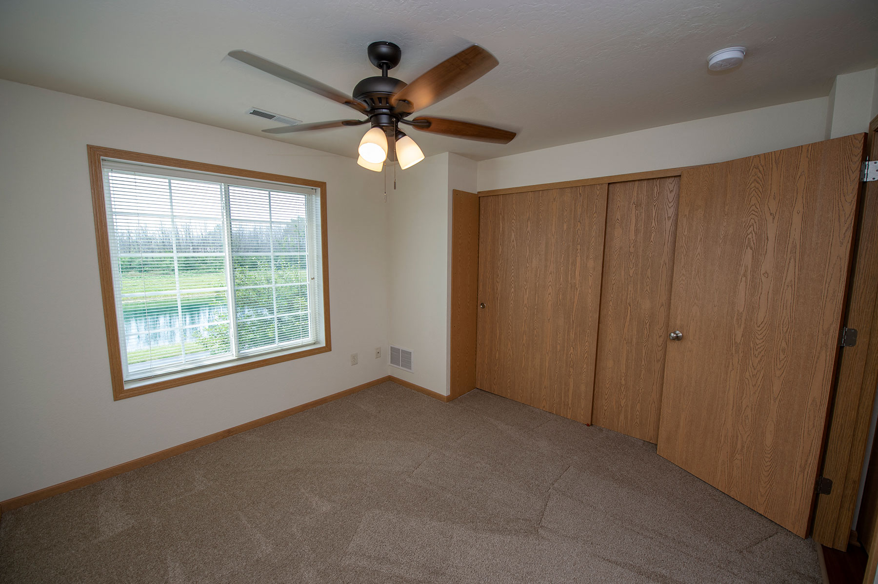 the master bedroom has a ceiling fan and a closet