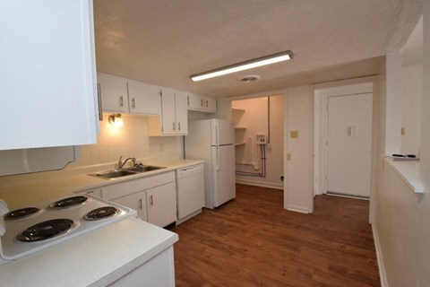 A kitchen with white cabinets and a stove top oven.