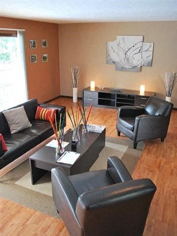 a living room with black leather chairs and a table