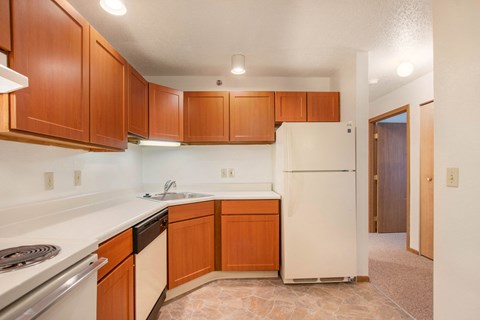 a kitchen with white appliances and wooden cabinets