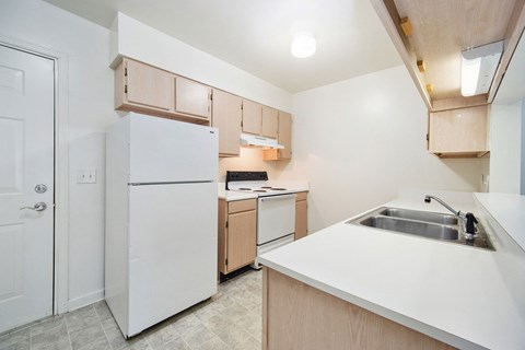 a kitchen with white appliances and wooden cabinets