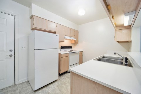 a kitchen with white appliances and wooden cabinets