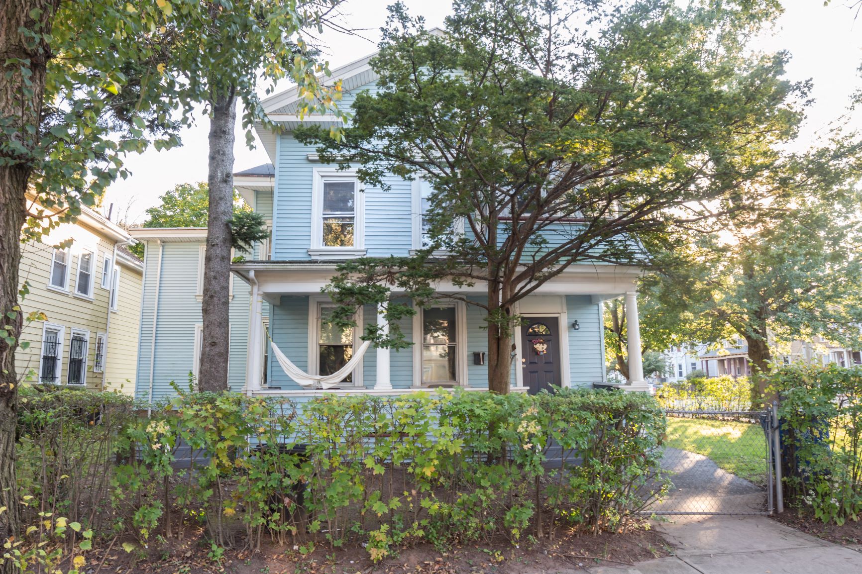 A blue house with a tree in front of it.