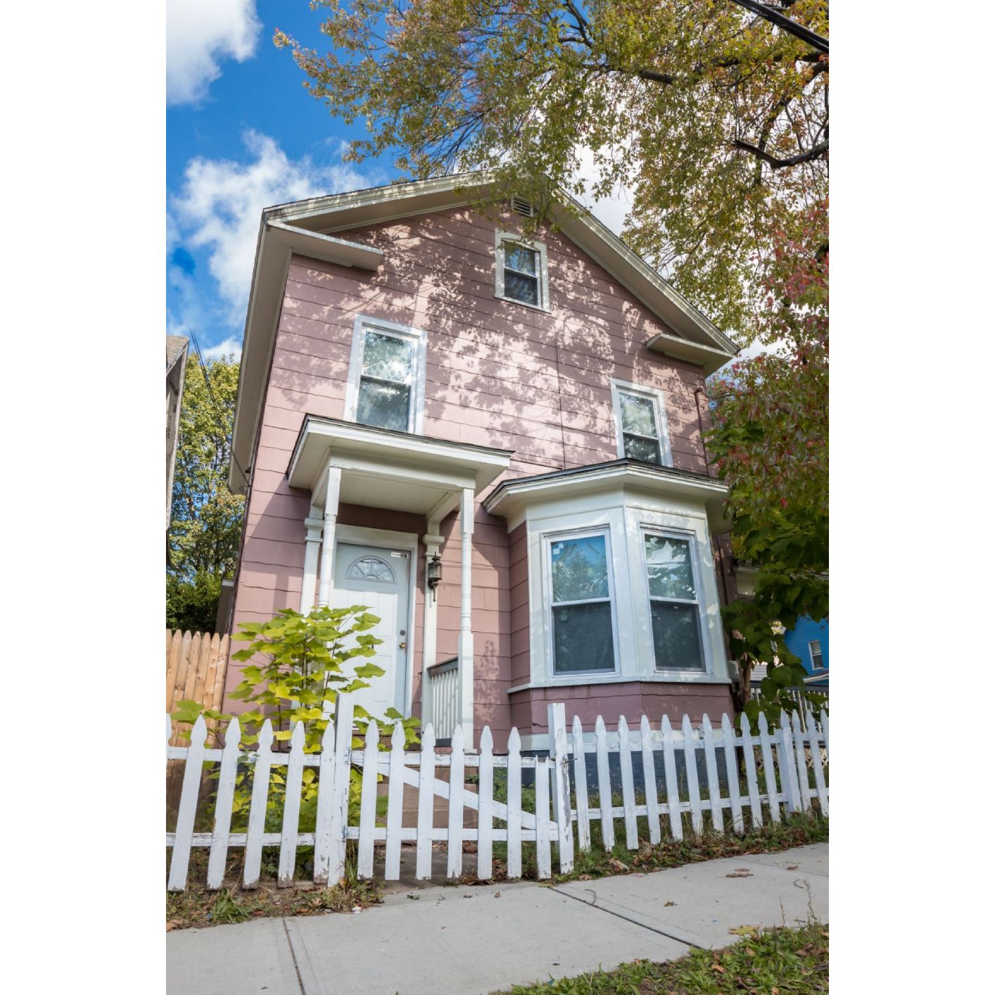 A house with a white picket fence in front.