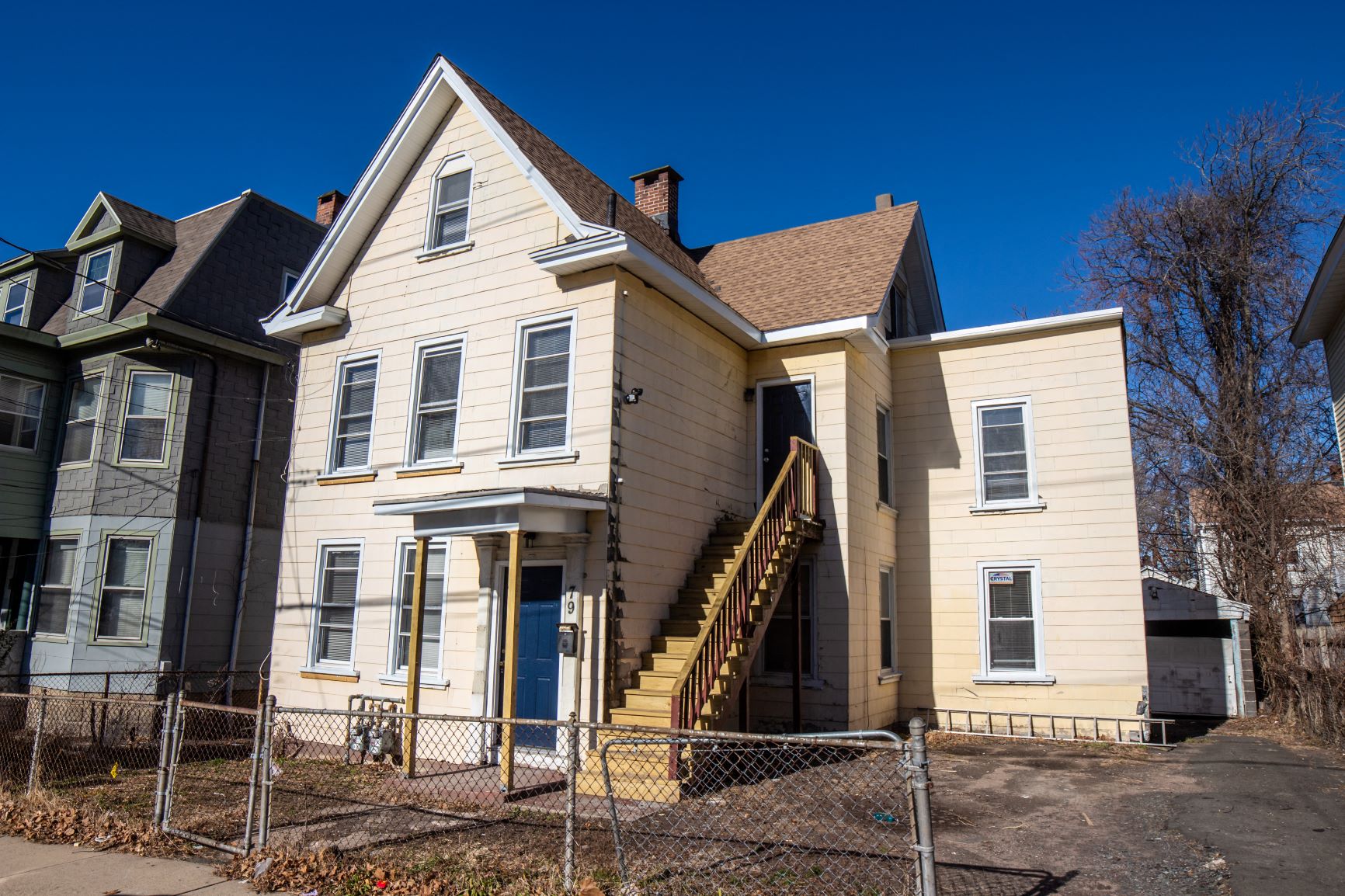 A large two-story house with a staircase leading to the front door.