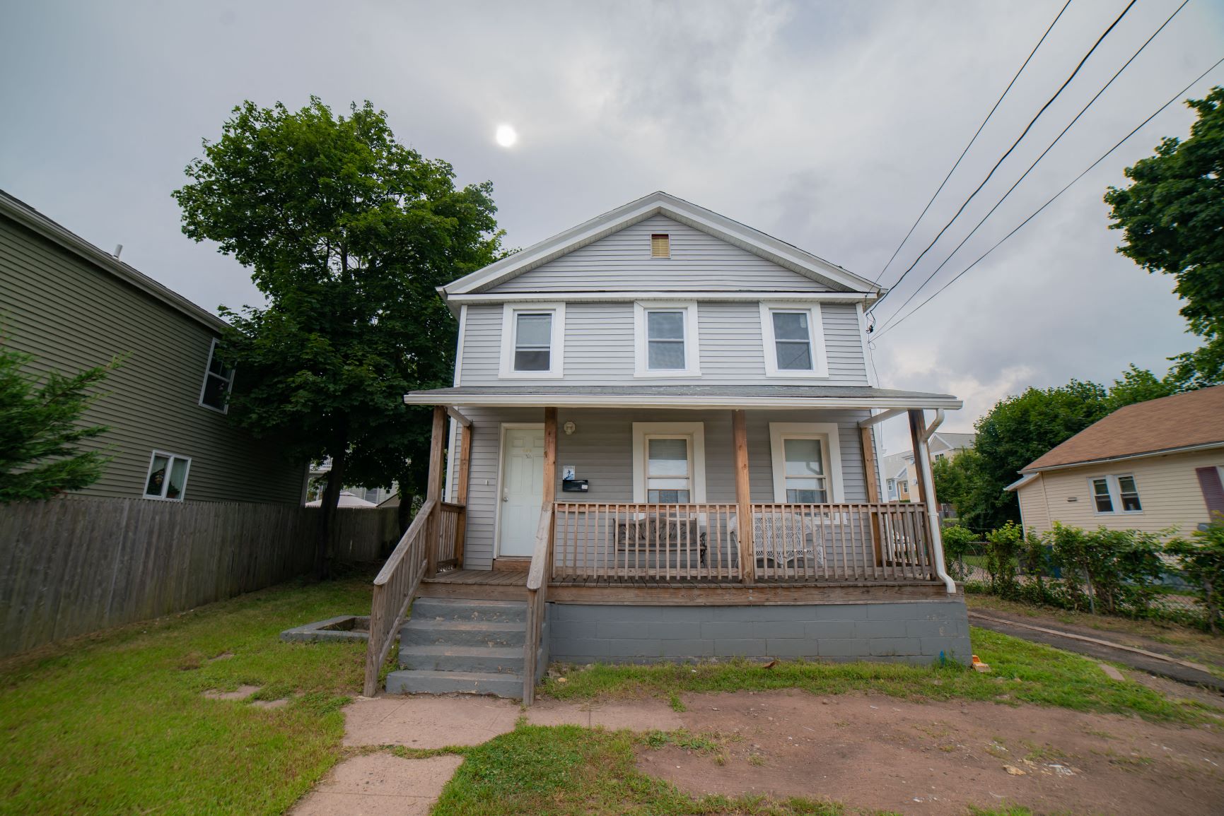A two-story house with a front porch and a small front yard.