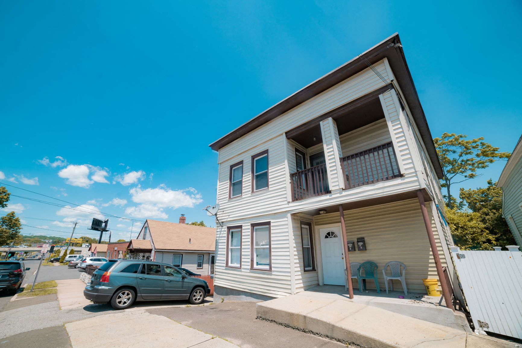 A two-story house with a car parked in front.