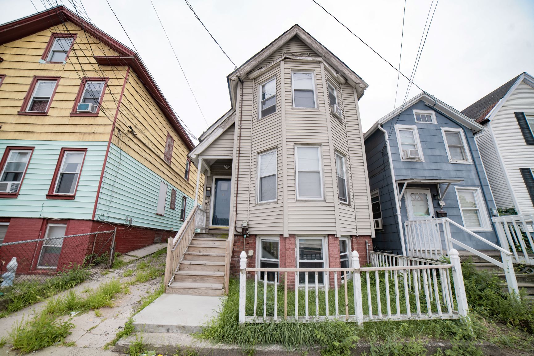 Three houses with different colored siding are shown.
