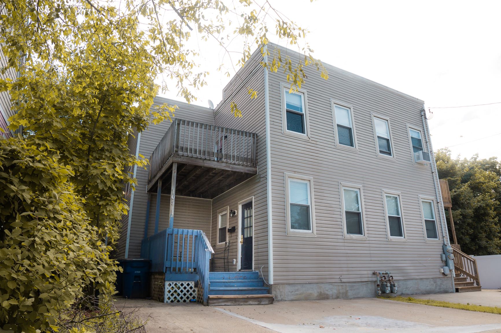 A grey house with a blue staircase.