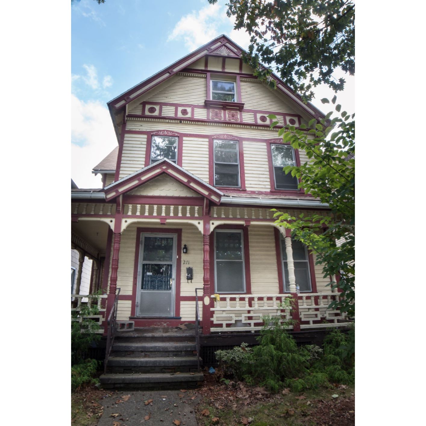 A two-story house with a red door and white trim.