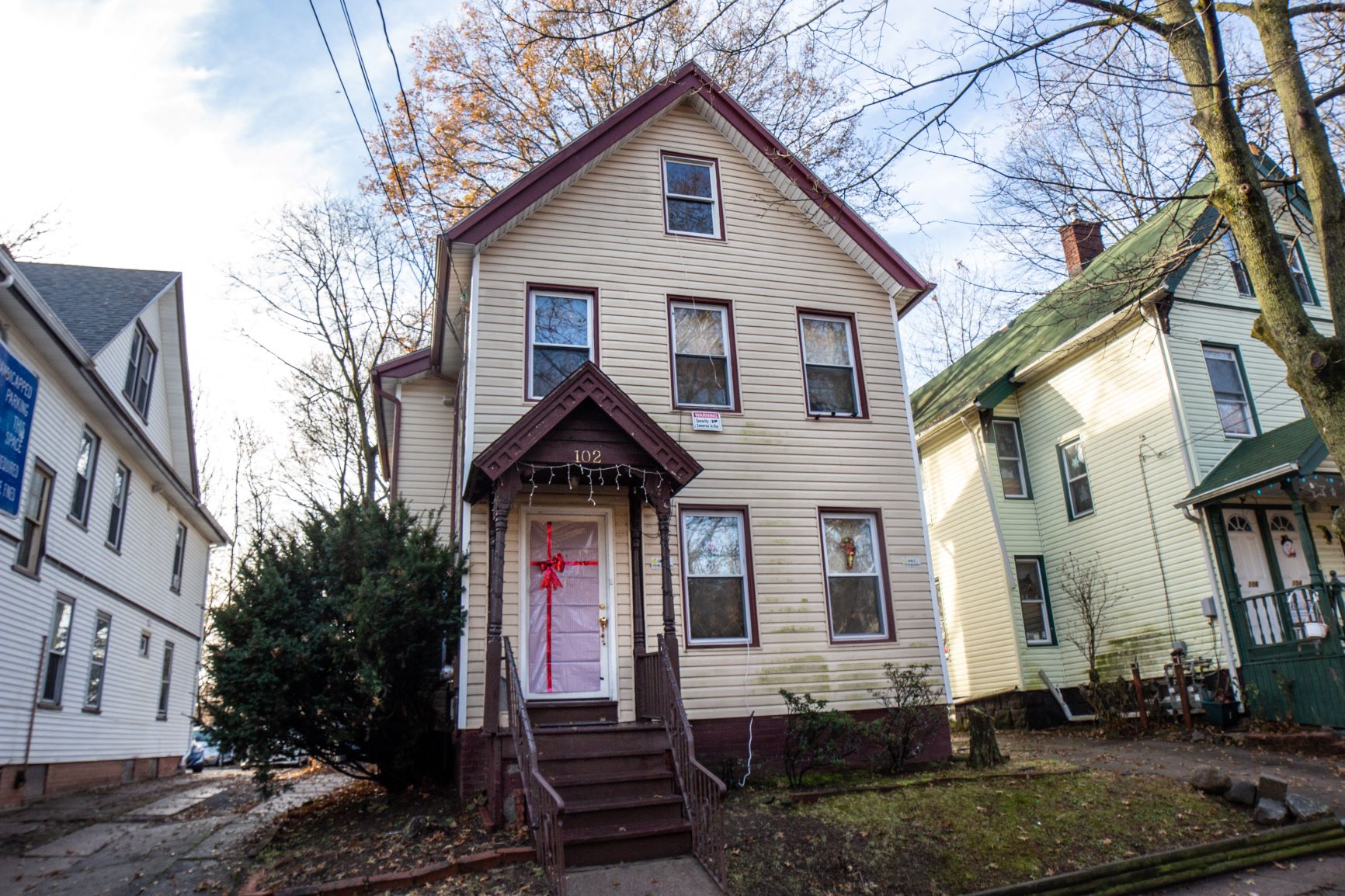 A house with a red door is in the center of the image.