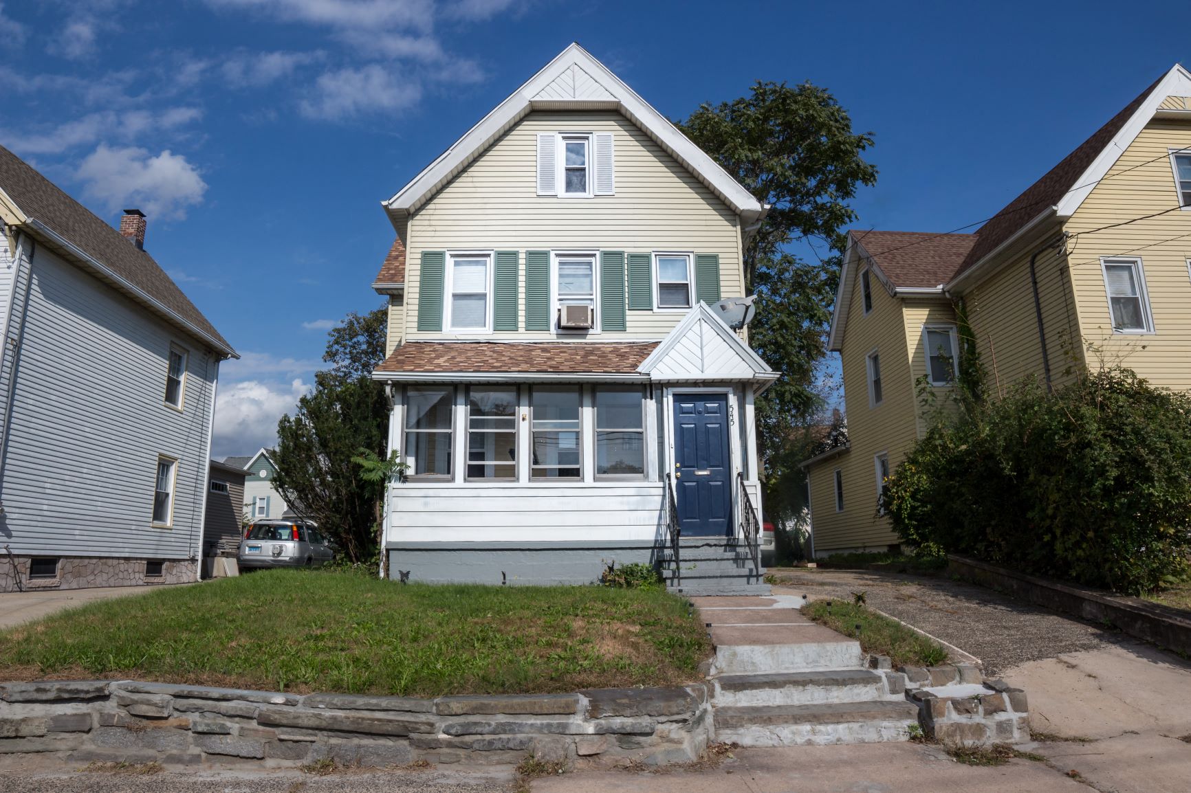 A two-story house with a blue door and white trim.