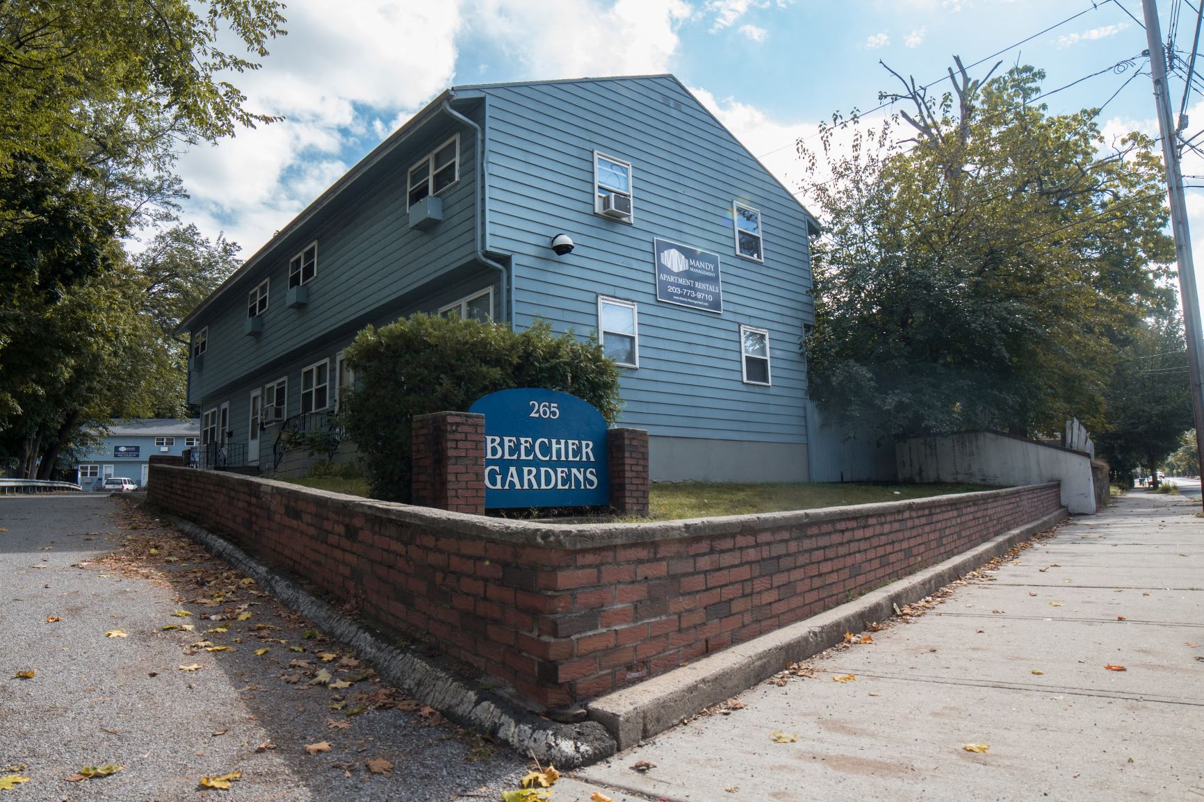A blue building with a sign that says Beecher Gardens.