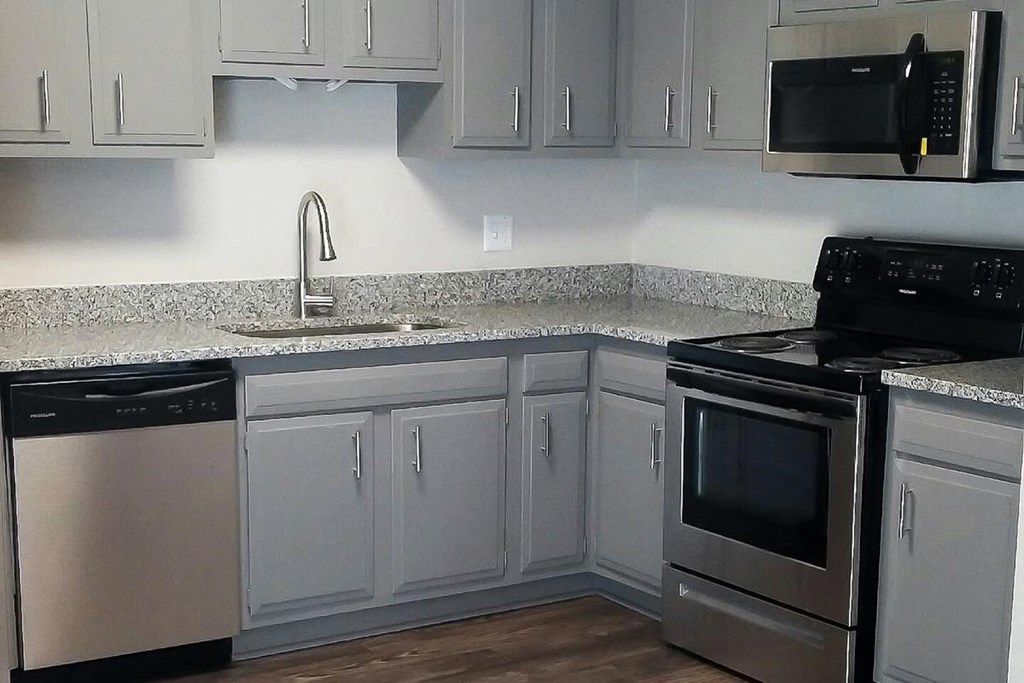 a kitchen with white cabinets and stainless steel appliances