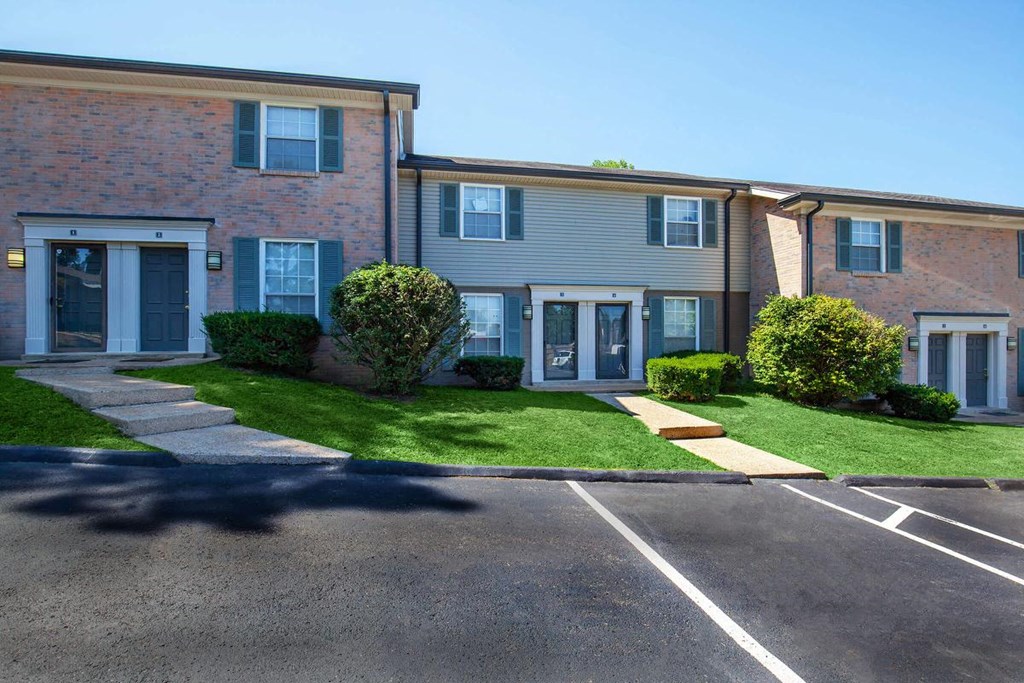 an apartment building with a lawn in front of it