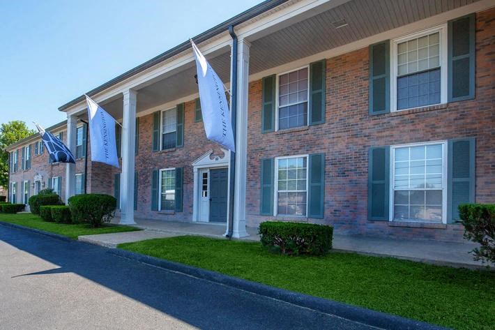 the front of a brick building with blue flags